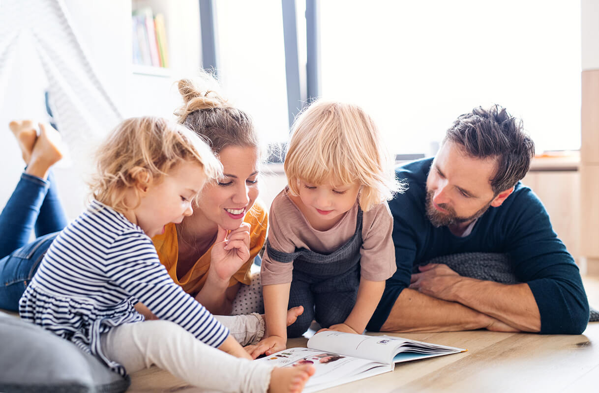 Family enjoying home comfort while reading a book together