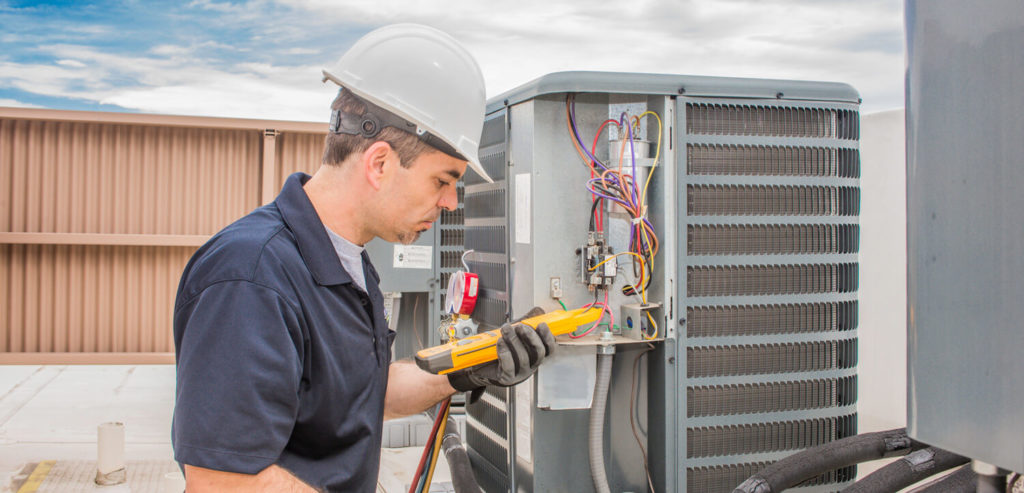 hvac technician working on rooftop unit