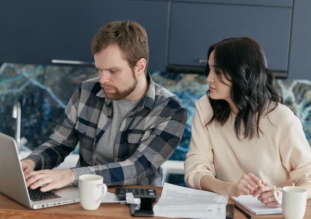 couple looking at bills and computer