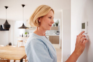 woman adjusts thermostat